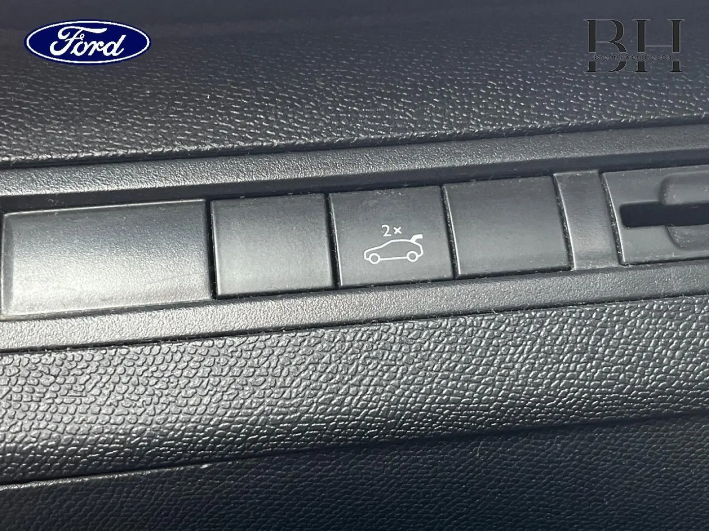 Bouton d'ouverture du hayon sur tableau de bord noir texturé du Peugeot 5008 noir Perla Nera, version 2018.