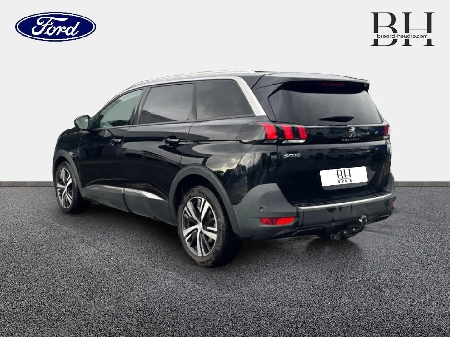 Peugeot 5008 noir Perla Nera vue 3/4 arrière gauche, avec barres de toit et jantes alliage visibles.