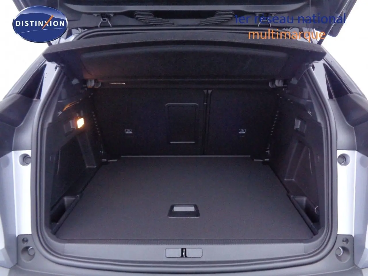 Coffre ouvert d'un Peugeot 3008 gris Artense Metal, montrant un espace de chargement propre et bien éclairé.