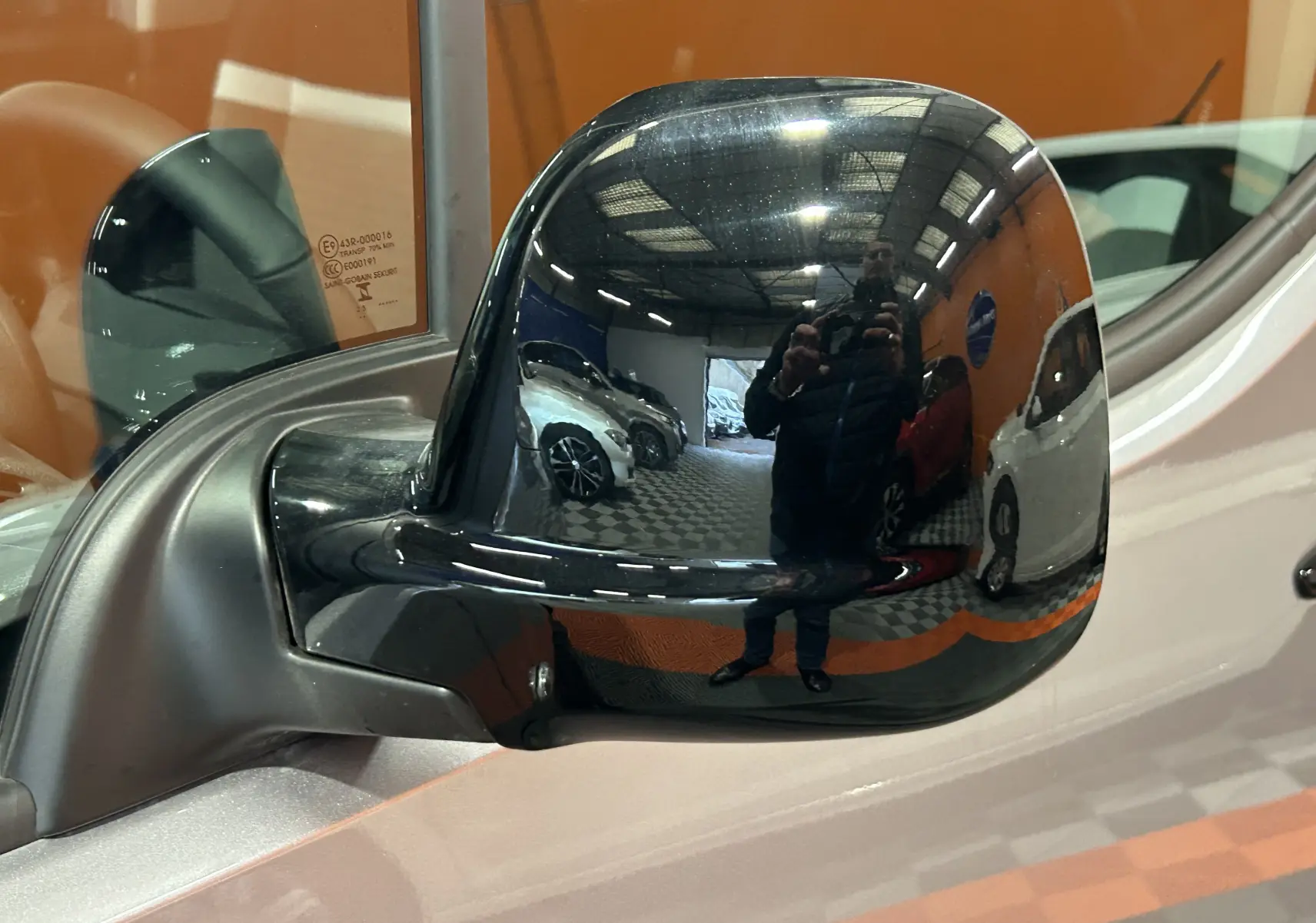 Rétroviseur extérieur noir du côté gauche du Citroën Berlingo Multispace gris Artense, reflet d'un garage intérieur.