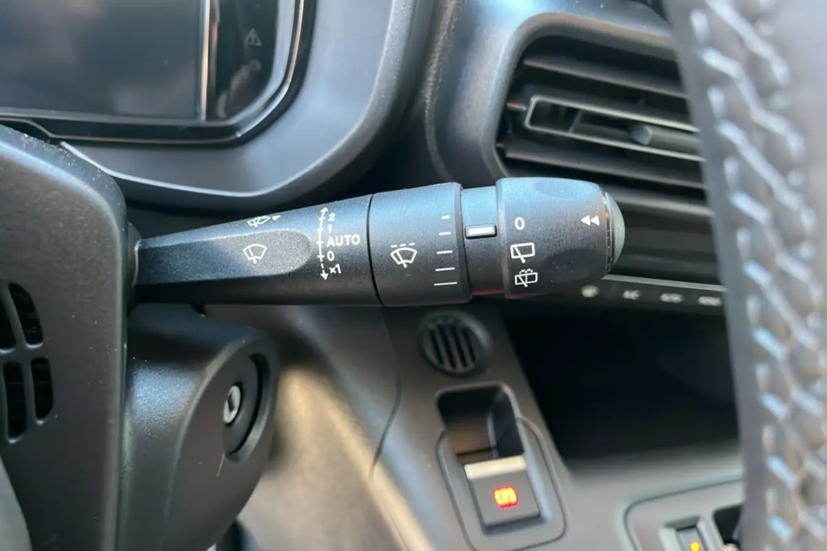Gros plan sur la commande d’essuie-glace à gauche du volant dans l’habitacle du Citroën Berlingo noir perla nera 2026.