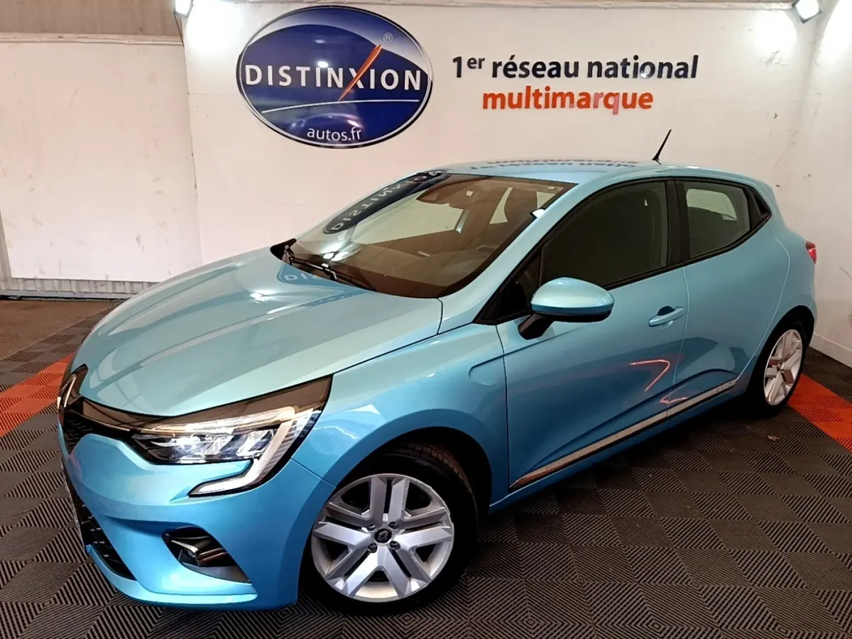 Renault Clio Business E-Tech hybride bleu vue 3/4 avant droit en intérieur avec jantes alliage et phares LED allumés.