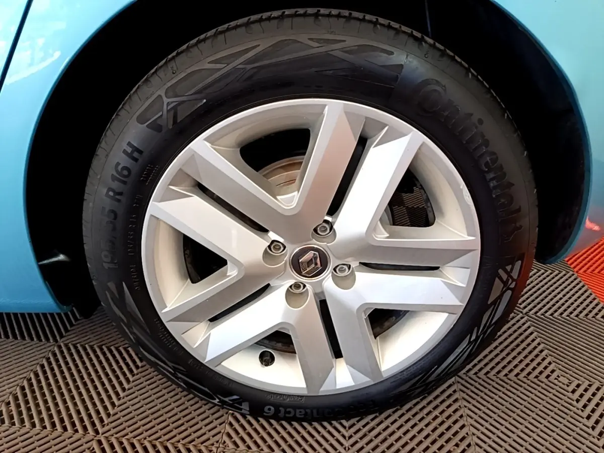 Gros plan sur la roue avant droite bleu clair d'une Renault Clio Business E-Tech hybride 2021 avec jante alliage argent.