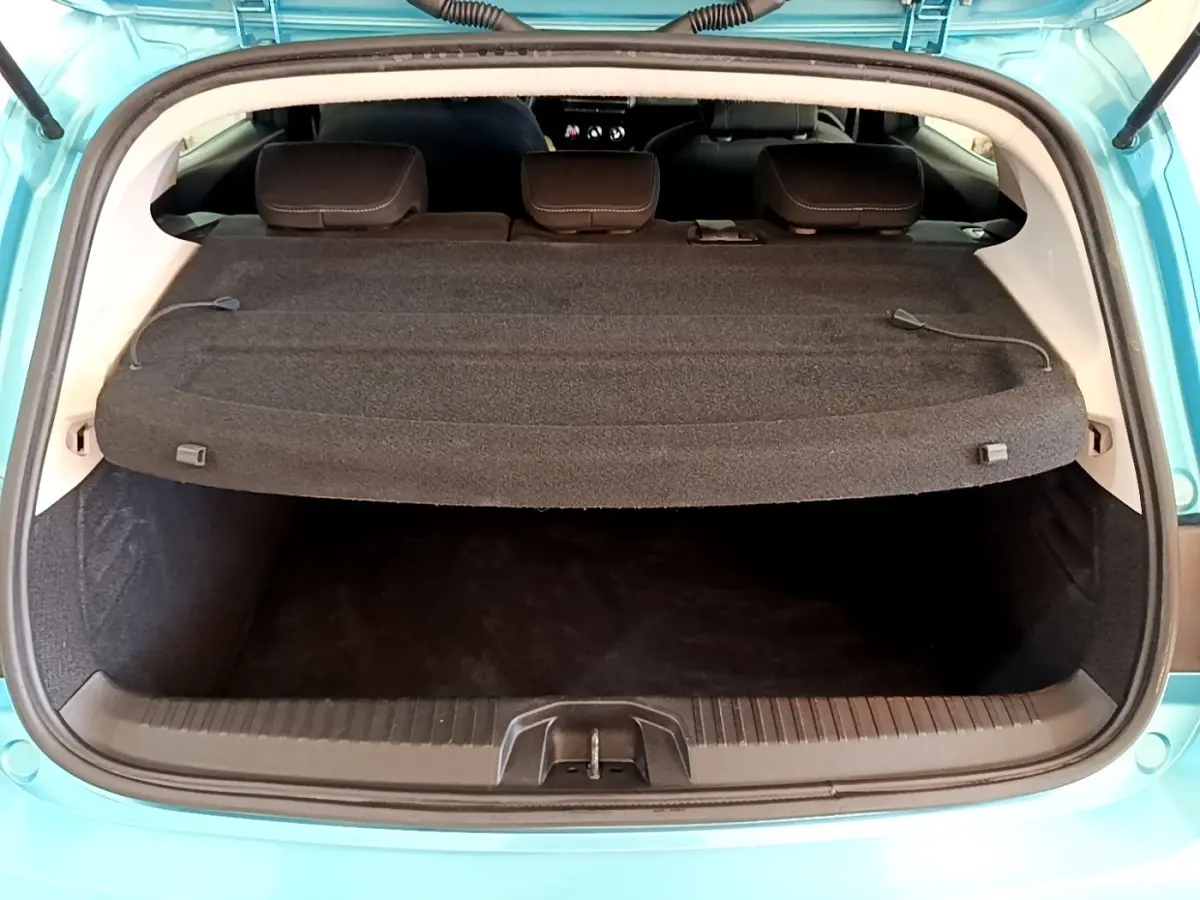 Coffre ouvert vu de l'arrière d'une Renault Clio Business E-Tech hybride bleu, avec tablette cache-bagages en place.