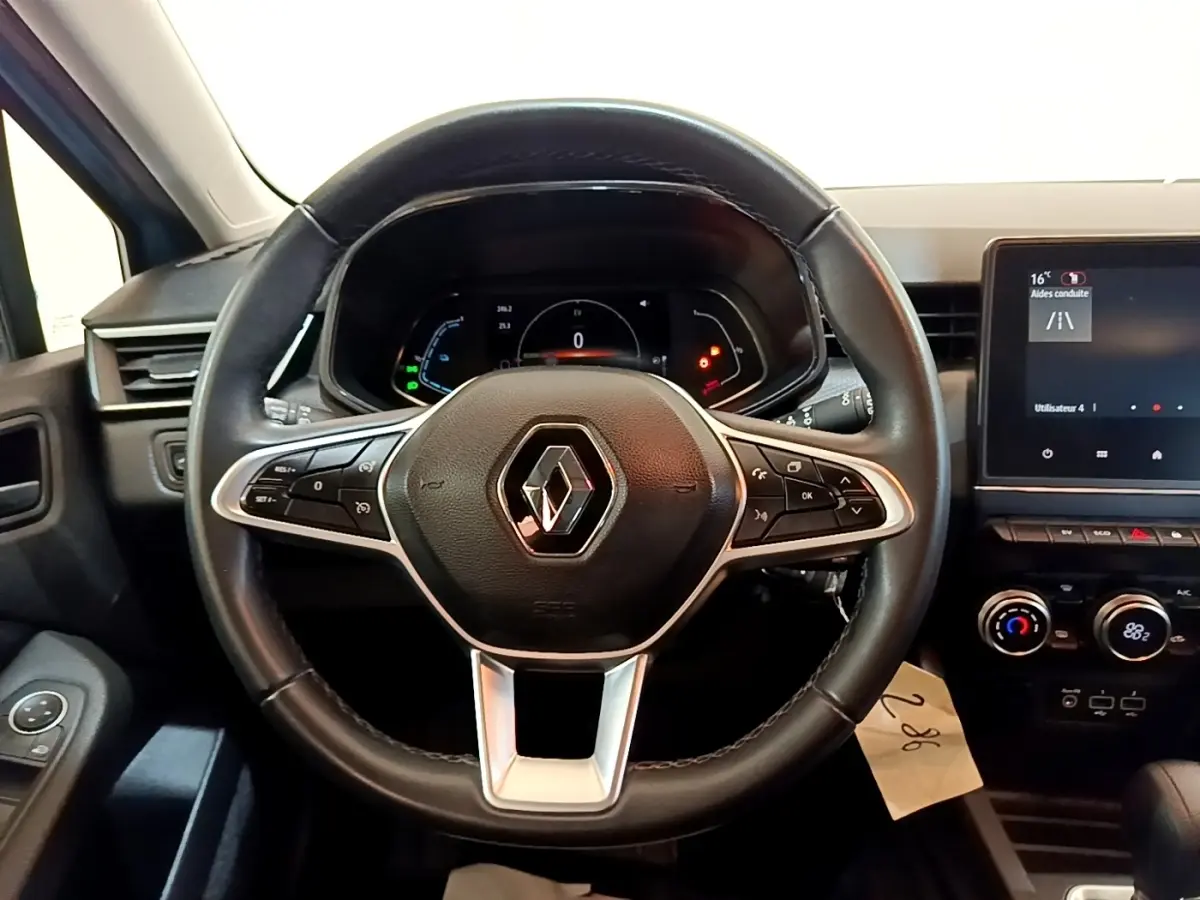 Vue centrée sur le volant cuir de la Renault Clio Business E-Tech hybride 2021 avec tableau de bord numérique et écran tactile.