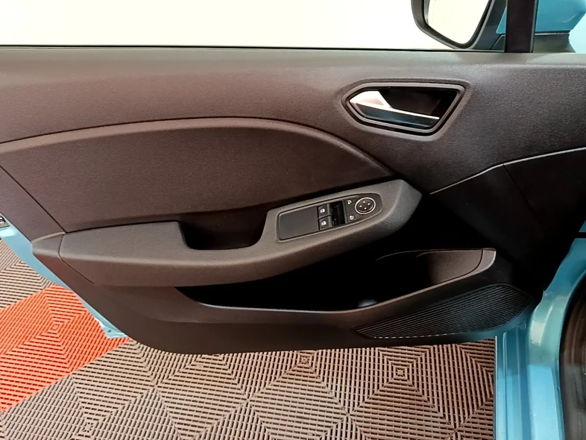 Vue intérieure du panneau de porte avant gauche d'une Renault Clio bleu, avec commandes électriques des vitres et rétroviseurs.