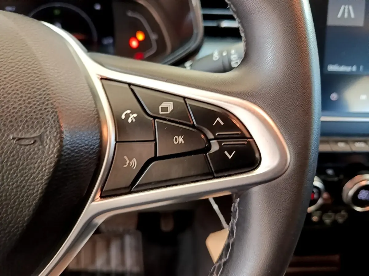 Gros plan sur les commandes multifonctions à droite du volant cuir noir de la Renault Clio Business E-Tech hybride 2021.