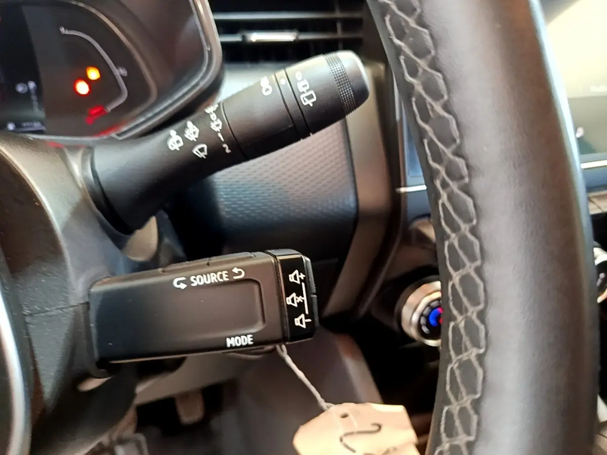 Gros plan sur la commande multifonctions à gauche du volant en cuir noir du Renault Clio Business E-Tech hybride 2021.