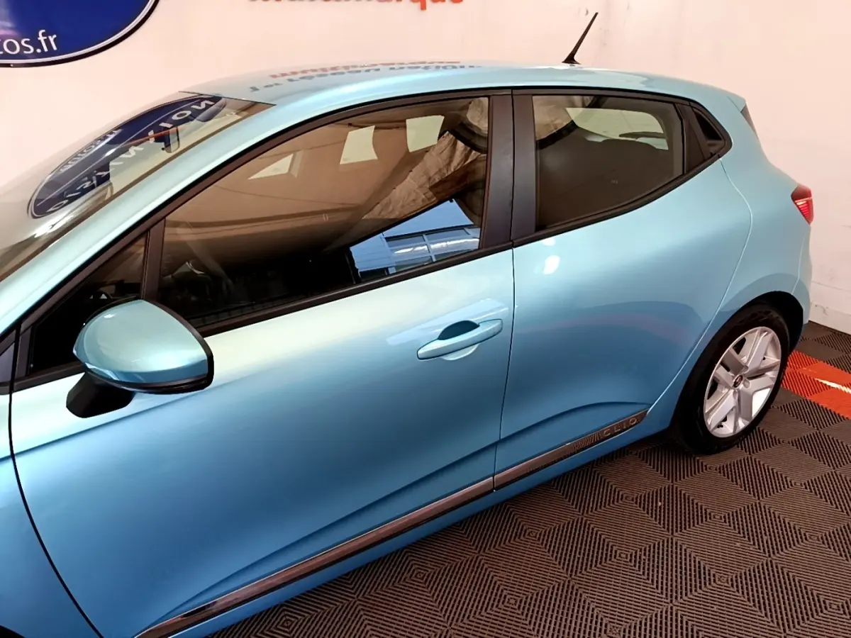 Profil droit d'une Renault Clio Business E-Tech hybride 140 bleu clair, avec jantes alliage et poignées de porte intégrées.