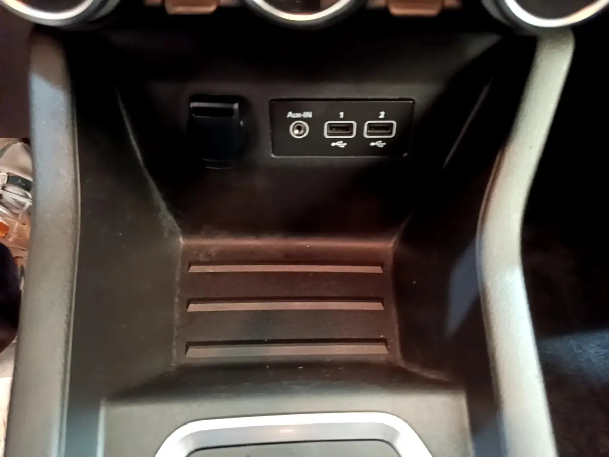 Vue rapprochée de la console centrale noire de la Renault Clio Business E-Tech hybride, avec ports USB et prise auxiliaire.
