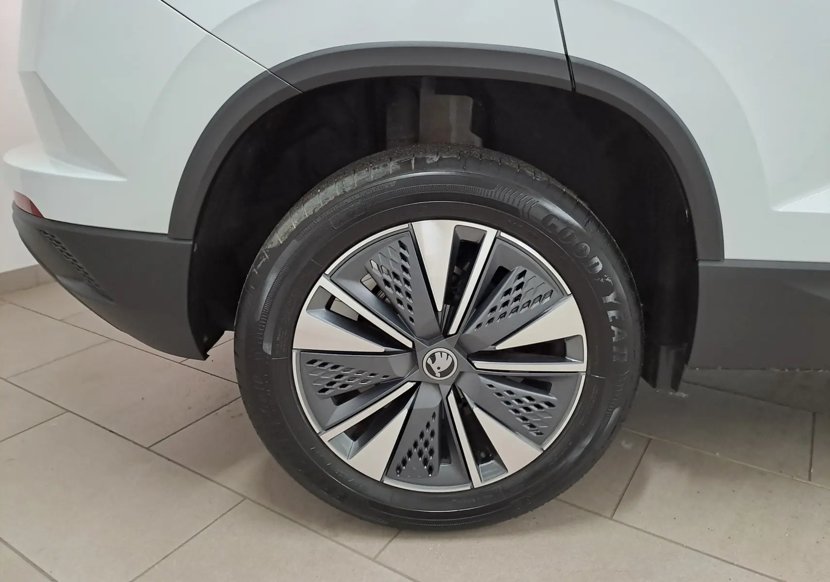 Gros plan sur la roue arrière droite du Skoda Karoq blanc Lune avec jante alliage au design moderne.