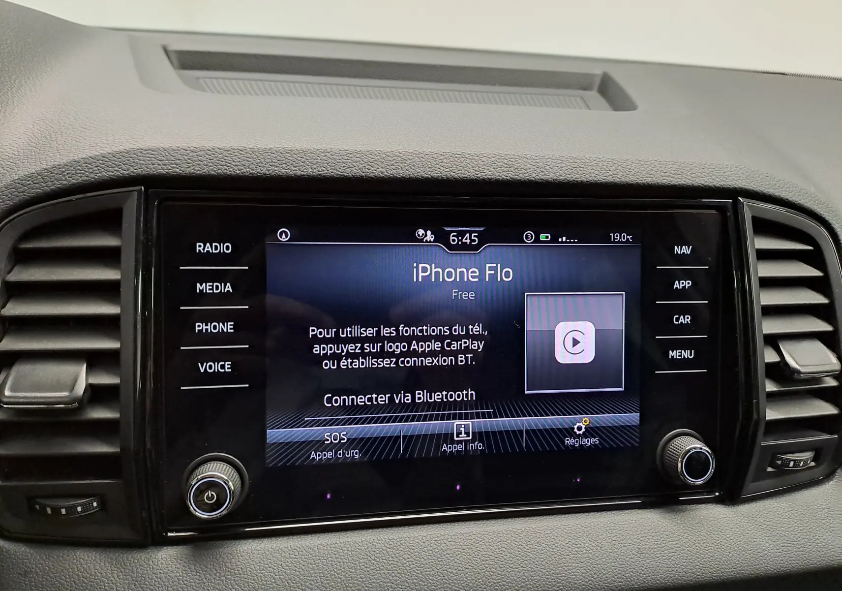 Écran tactile central du Skoda Karoq 1.5 TSI blanc, affichant la connexion Bluetooth et les commandes multimédia.