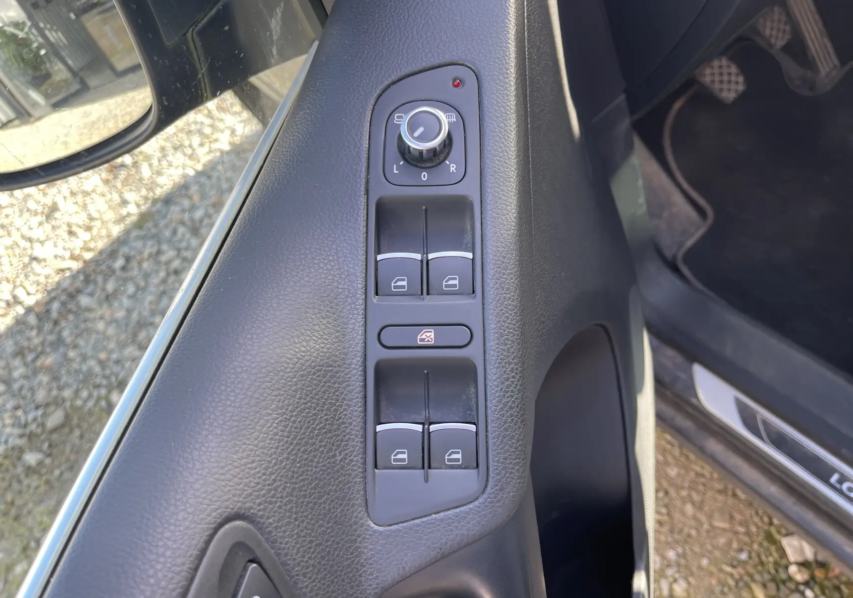 Vue rapprochée du panneau de commandes des vitres et rétroviseurs côté conducteur du Volkswagen Tiguan gris foncé 2015.