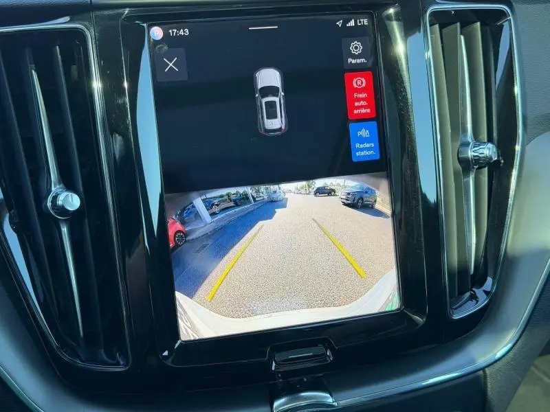 Écran tactile central affichant la caméra de recul du Volvo XC60 T6 gris, avec guidage de trajectoire jaune.