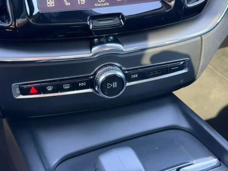 Détail de la console centrale du Volvo XC60 2024 avec molette de contrôle multimédia et boutons de fonction noirs chromés.
