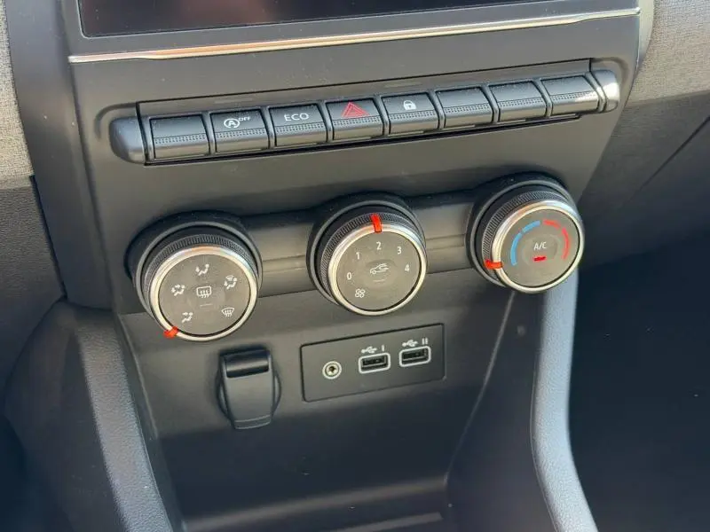 Gros plan sur les commandes de climatisation et les ports USB du tableau de bord gris foncé d'une Renault Clio 1.5 dCi 2025.