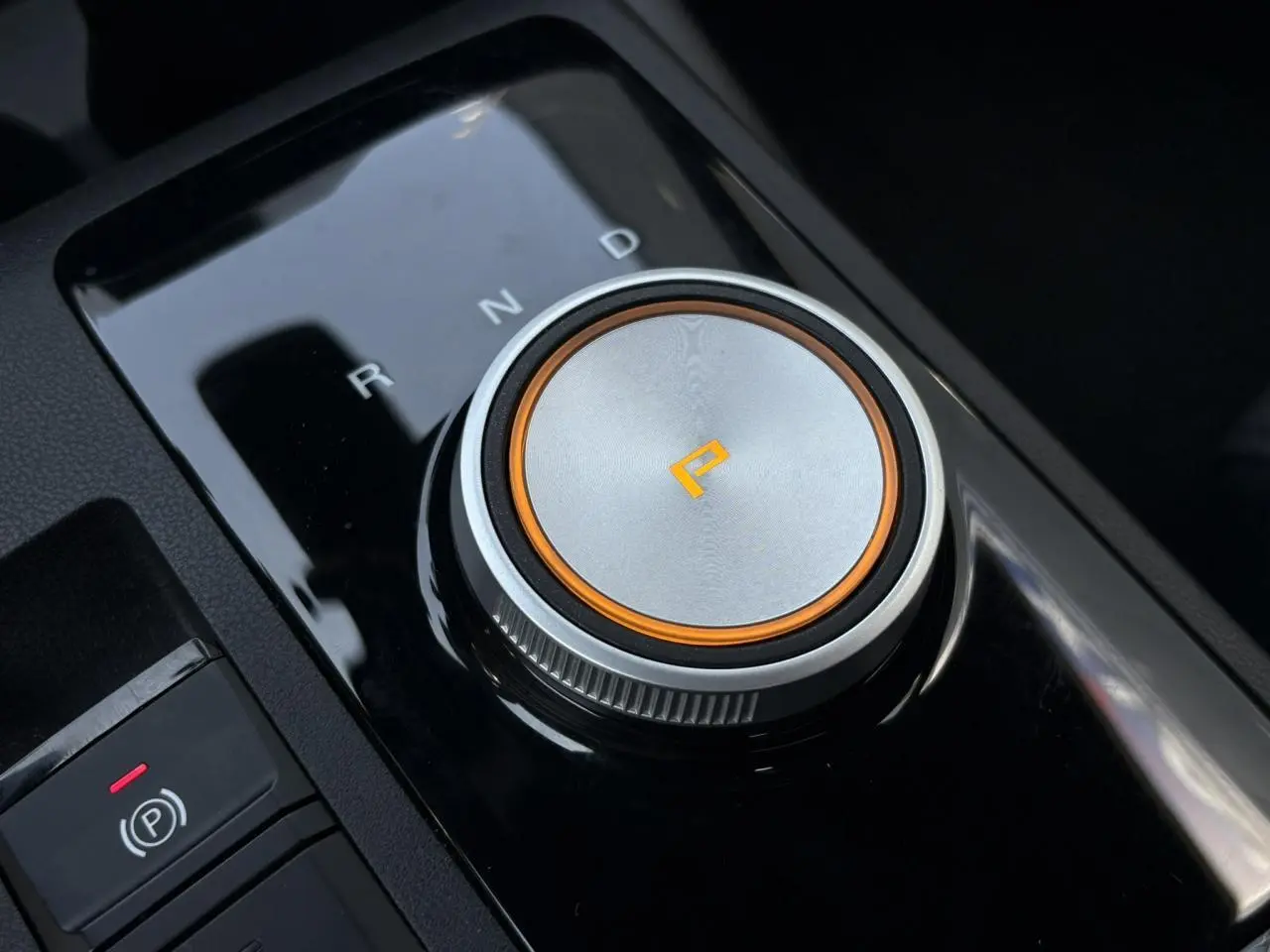 Gros plan sur la molette de sélection de la boîte automatique du MG3 1.5 Hybrid+ blanc, avec éclairage orange autour du mode parking.