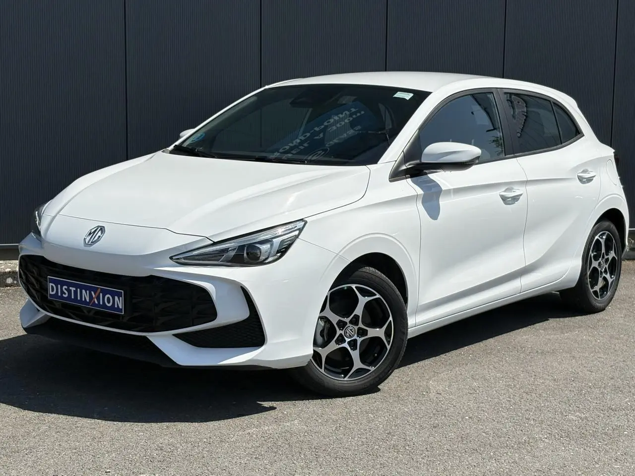 MG3 blanc Dover en 3/4 avant droit, avec jantes alliage noires et calandre noire distinctive.