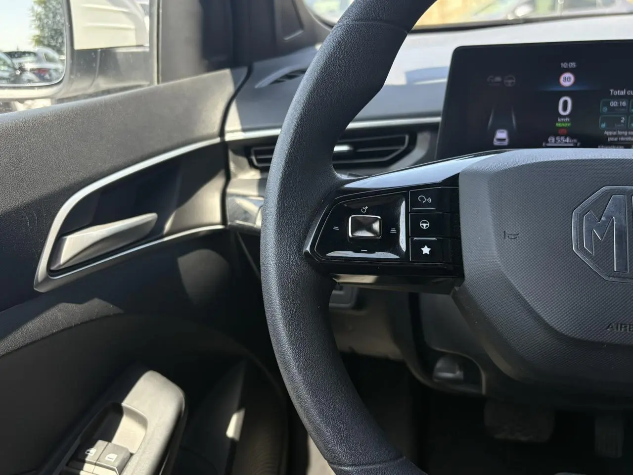 Vue intérieure centrée sur le volant noir MG3 2025 avec commandes multifonctions et tableau de bord numérique.