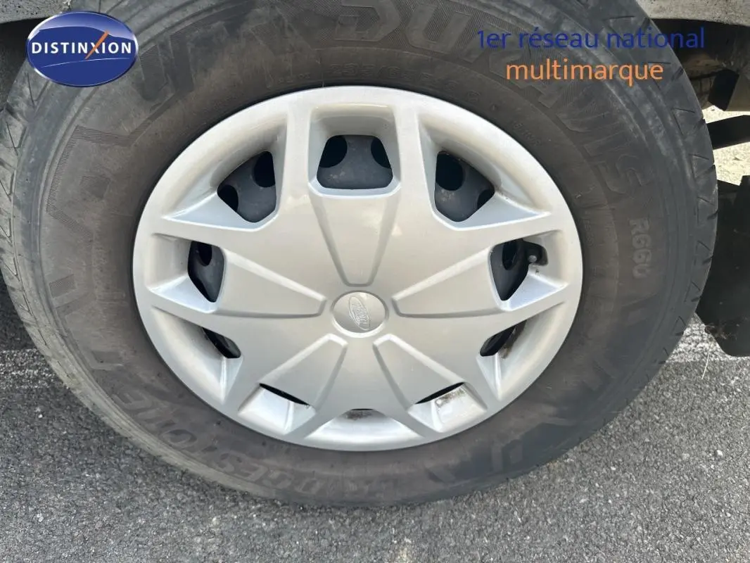 Gros plan sur la jante classique 16 pouces d'un Ford Transit Fourgon blanc, avec logo Ford au centre.