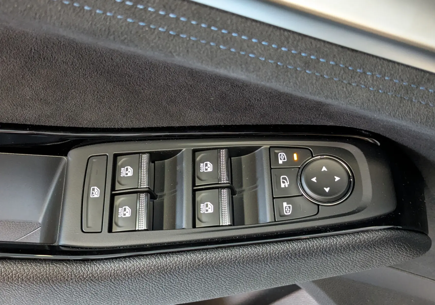 Panneau de commandes des vitres et rétroviseurs sur la porte côté gauche d'un Renault Austral gris schist 2025.