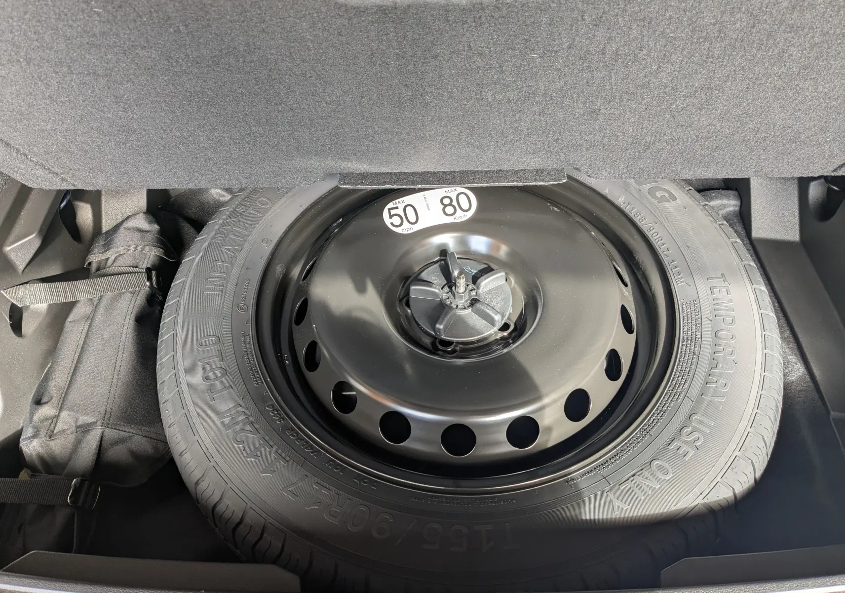 Roue de secours montée dans le coffre du Renault Austral gris schist e-tech full hybrid 2025, hayon motorisé visible.