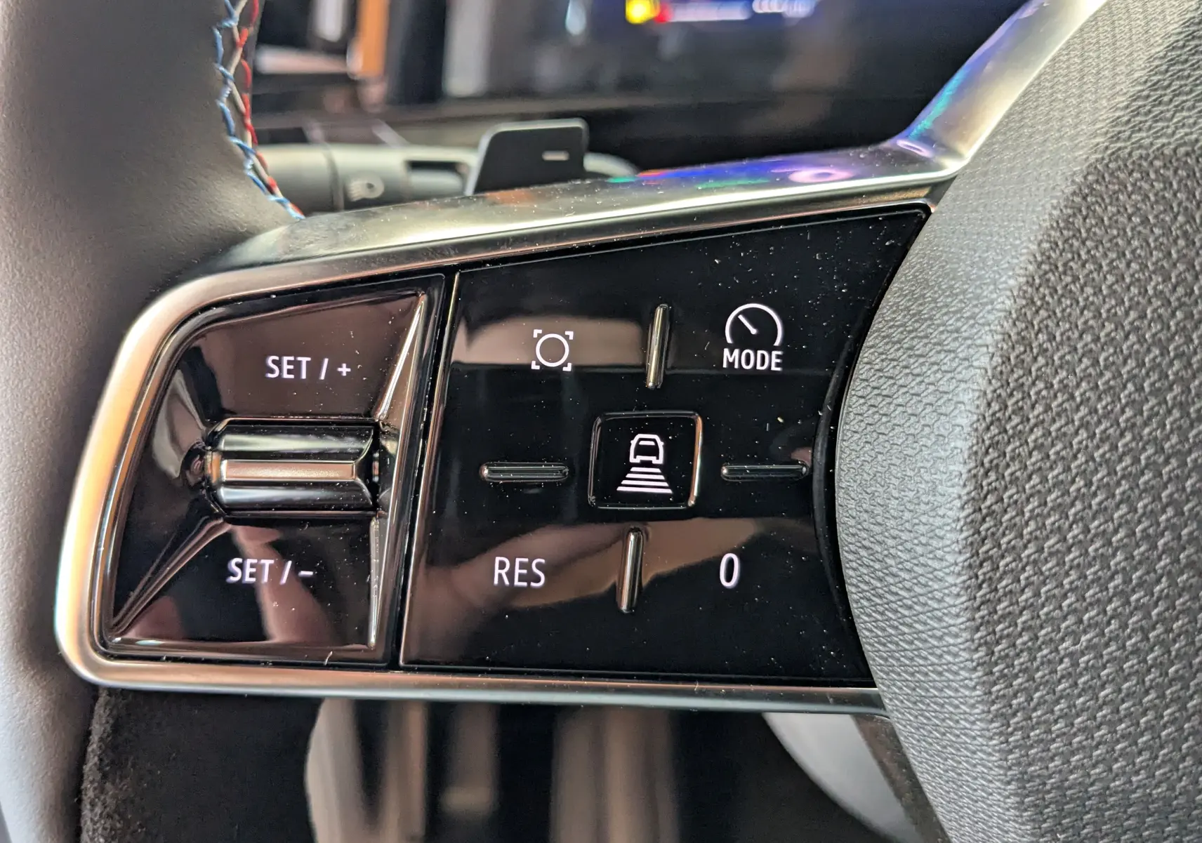 Gros plan sur les commandes de régulateur de vitesse au volant du Renault Austral gris schist 2025 hybride.
