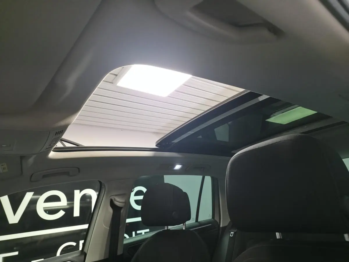 Intérieur du Volkswagen Tiguan 2020, vue arrière des sièges noirs avec toit ouvrant panoramique ouvert.