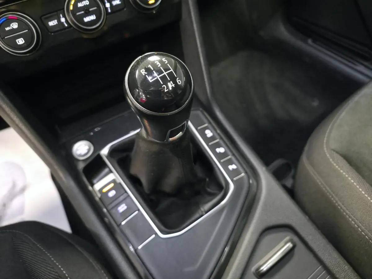 Le levier de vitesses manuel noir du Volkswagen Tiguan 2020 vu de dessus, entouré de commandes sur la console centrale.