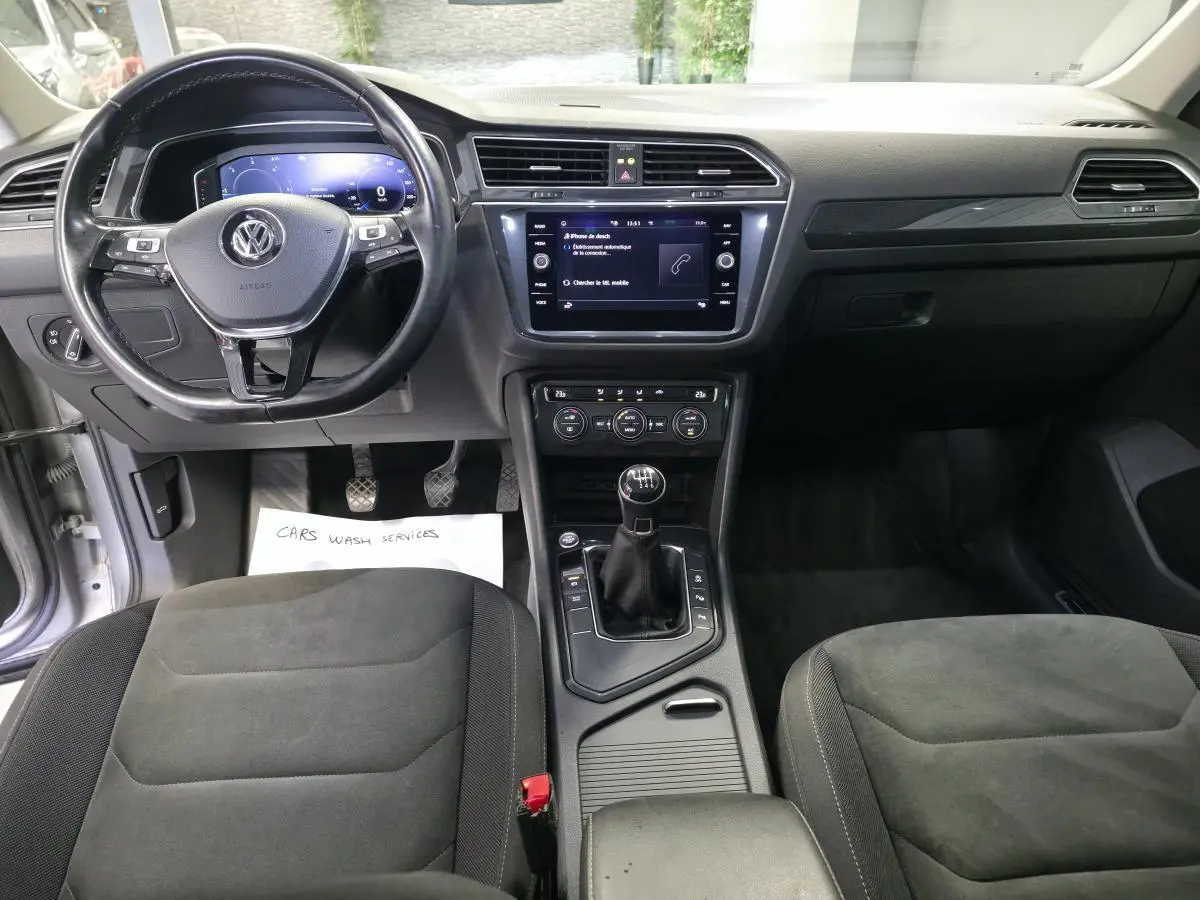 Intérieur avant du Volkswagen Tiguan 2020, vue centrée sur le volant cuir multifonctions et la console avec boîte manuelle.