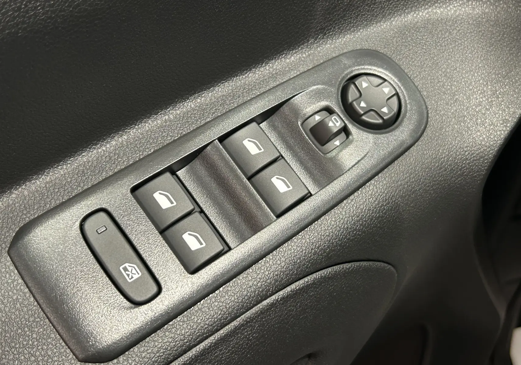 Panneau de commandes des vitres électriques et réglage des rétroviseurs côté conducteur d'un Citroën Berlingo Multispace gris Artense.