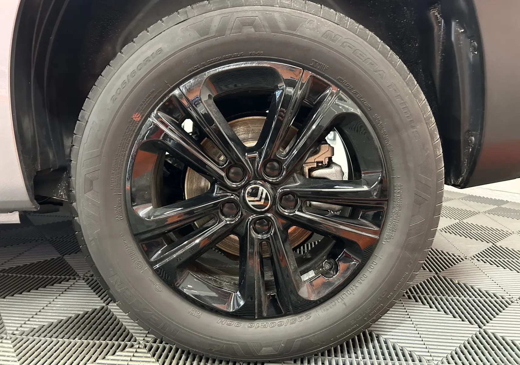 Gros plan sur la roue avant droite avec jante noire brillante du Citroën Berlingo Multispace gris Artense 2025.