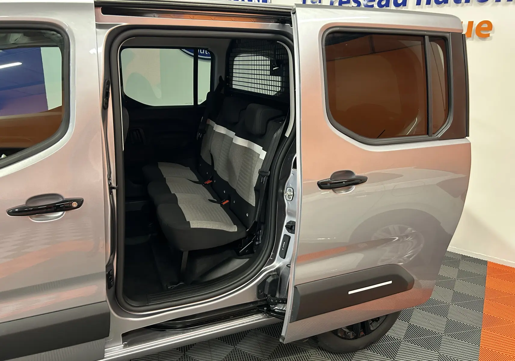 Vue latérale droite du Citroën Berlingo Multispace gris Artense avec porte coulissante ouverte et sièges arrière visibles.