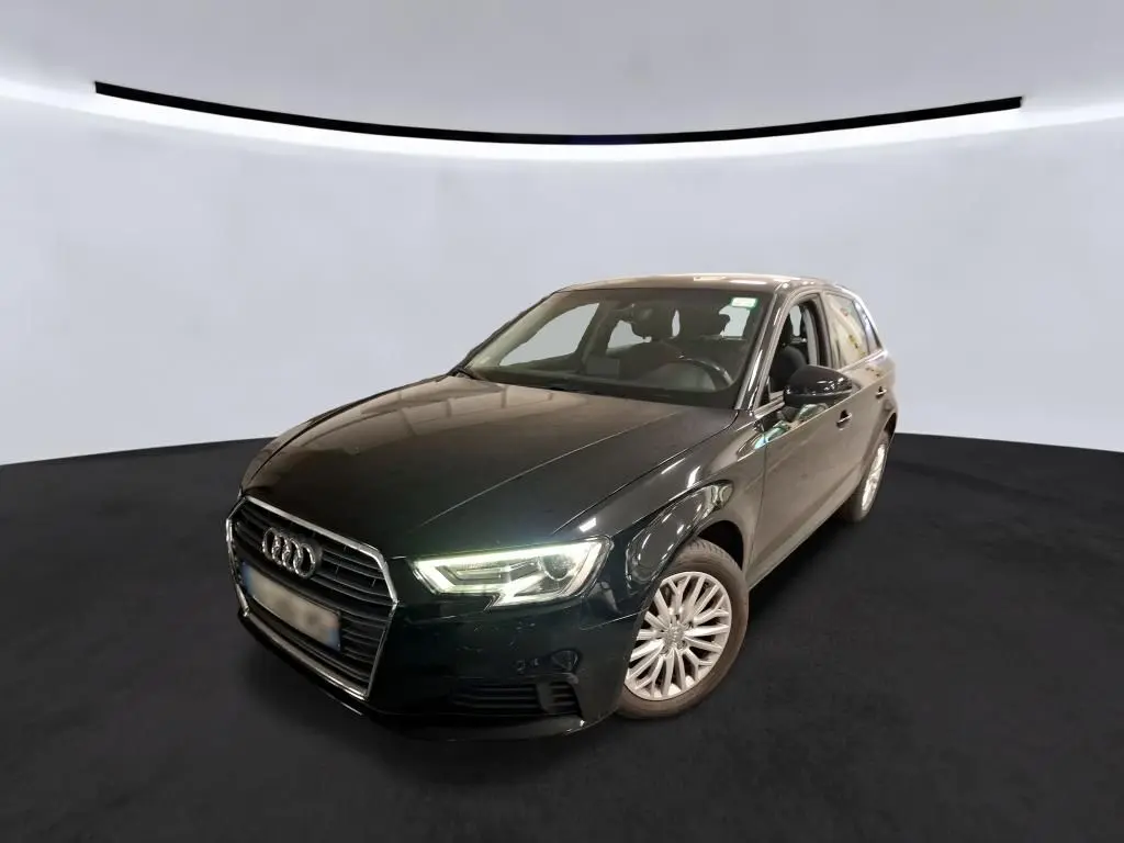 Audi A3 Sportback noir vue 3/4 avant droit avec phares allumés et jantes aluminium 10 branches.