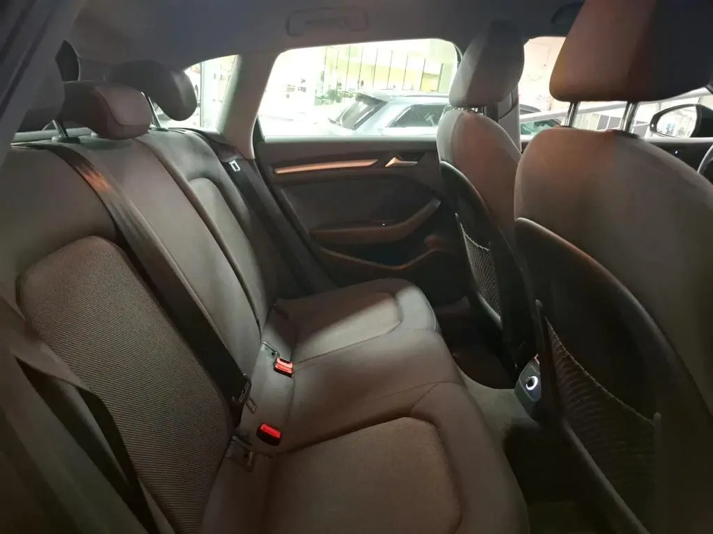 Vue intérieure côté droit de la banquette arrière noire de l'Audi A3 Sportback 2017 avec appuie-têtes et ceintures visibles.