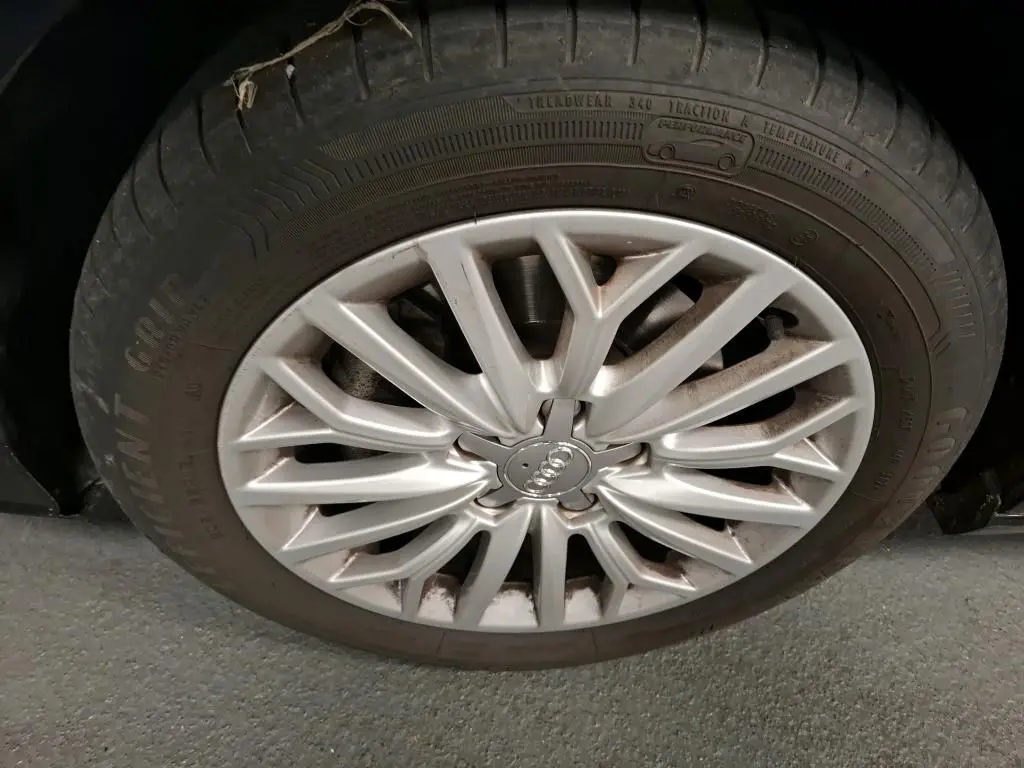 Gros plan sur la jante en aluminium 10 branches de l'Audi A3 Sportback noire, roue avant droite visible.