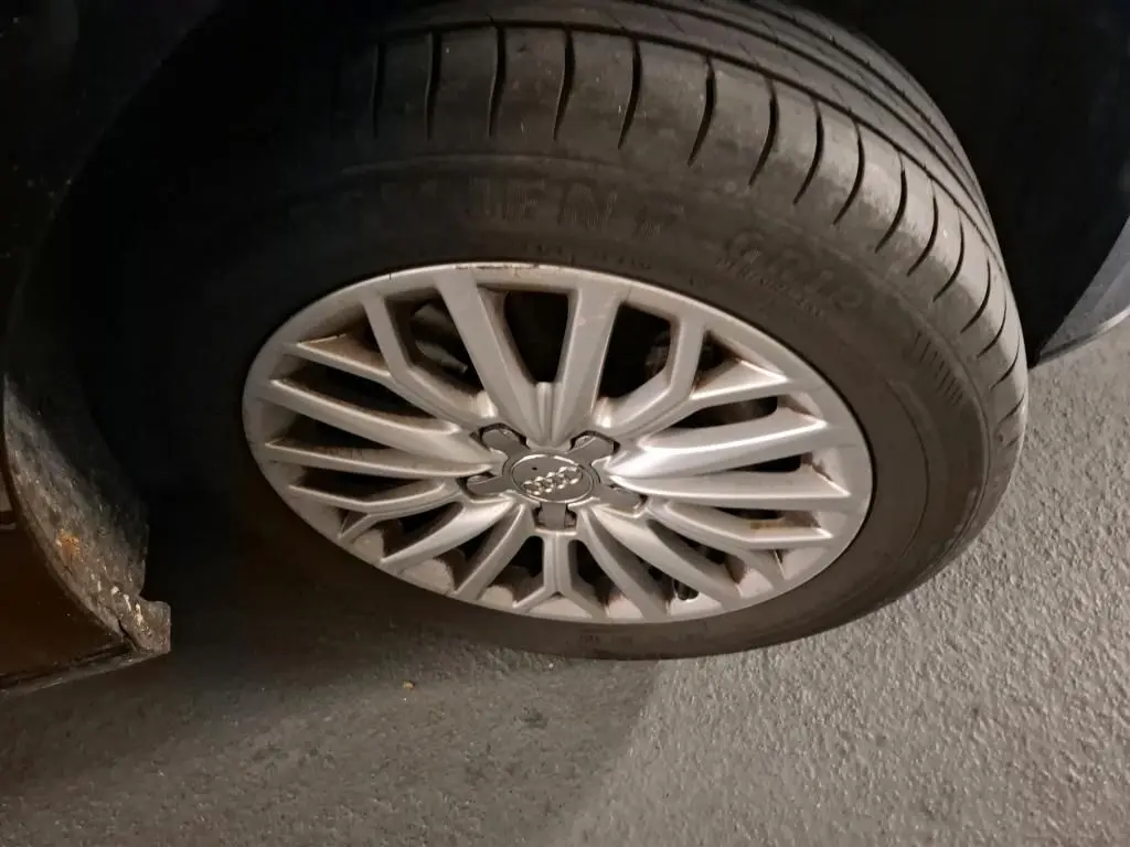 Gros plan sur la jante en aluminium 10 branches argentée d'une Audi A3 Sportback noire, vue côté roue avant.