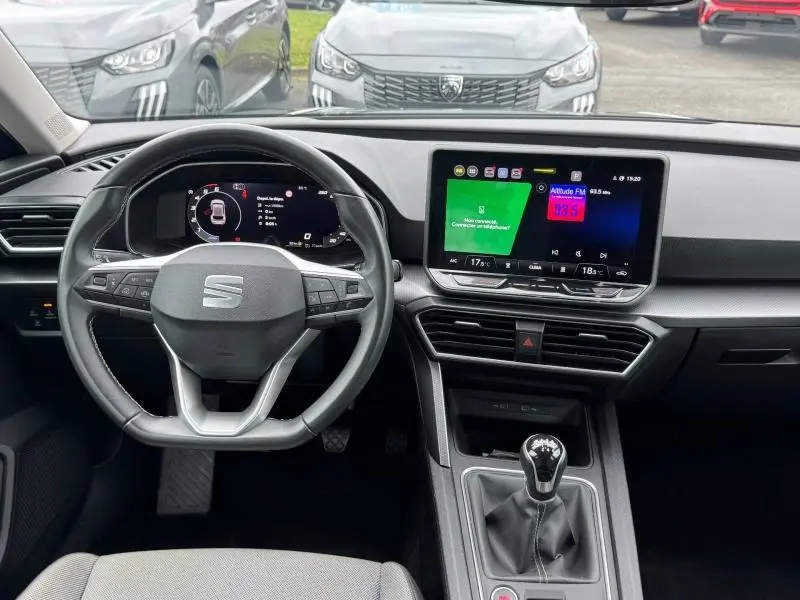 Vue intérieure frontale du poste de conduite du SEAT LEON 2.0 TDI 115ch STYLE XL 2025 avec écran tactile et volant multifonction.