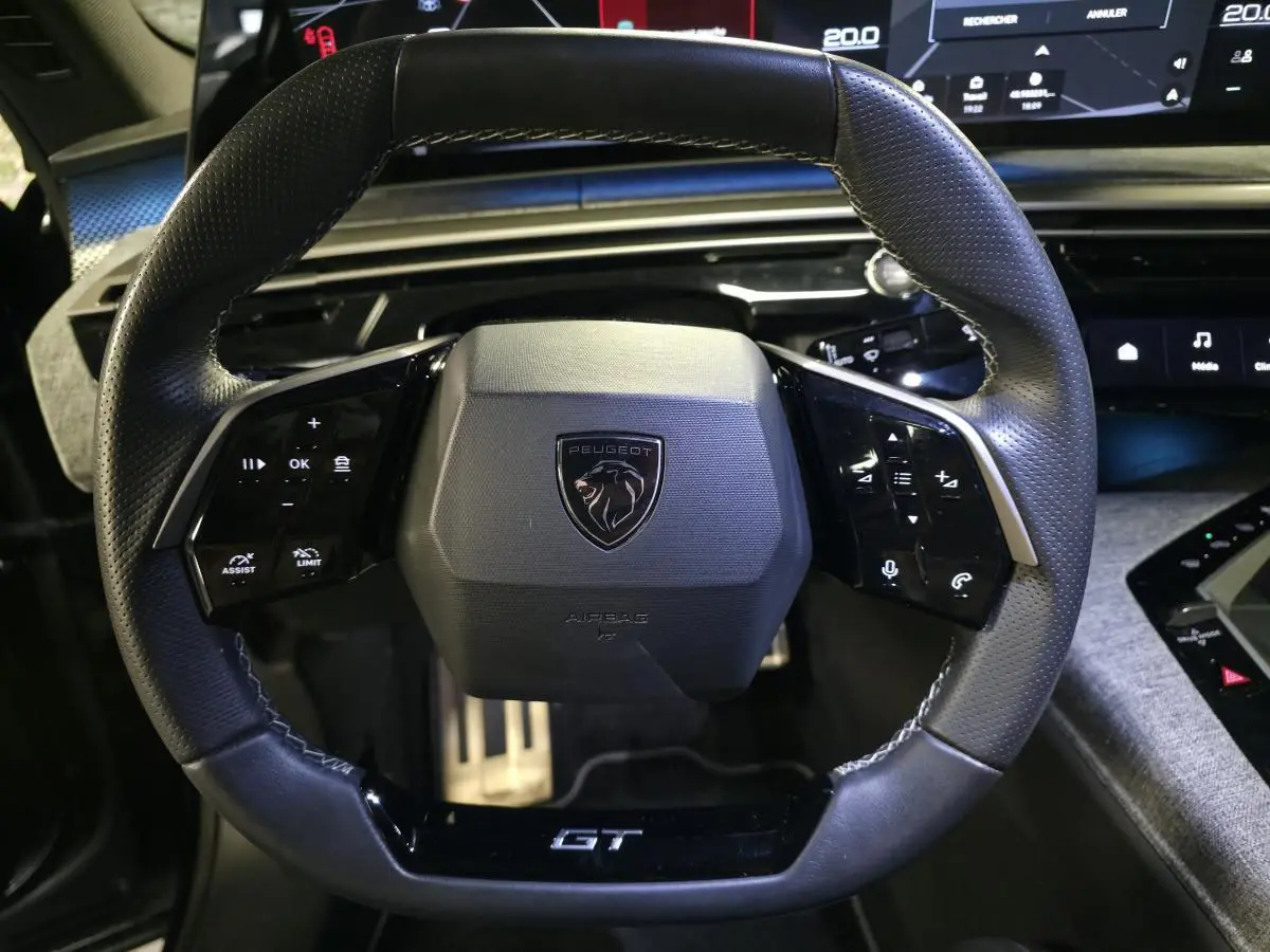 Volant cuir noir GT de Peugeot 3008 2025, vue de face avec commandes intégrées et logo central lion.