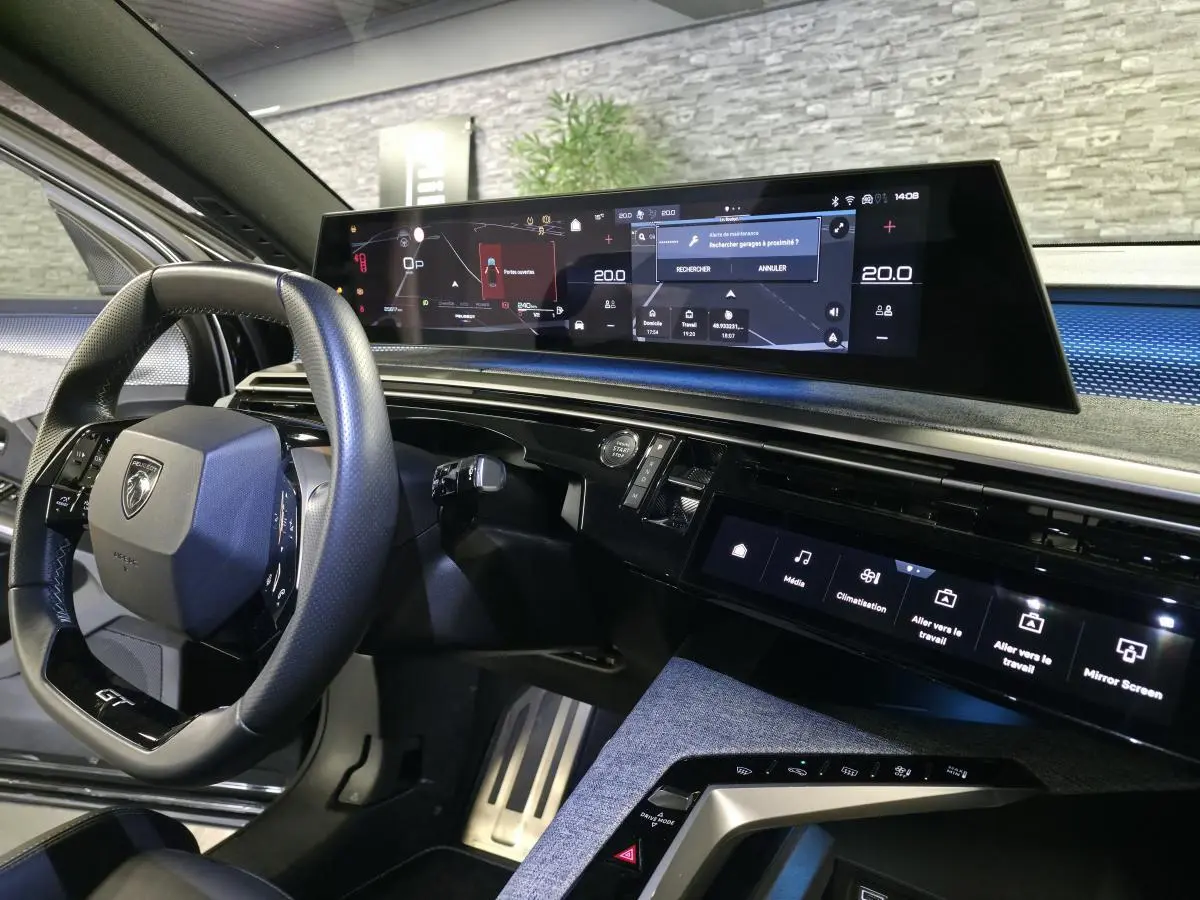 Intérieur du Peugeot 3008 2025 noir, vue du poste de conduite avec écran panoramique incurvé et volant compact GT.