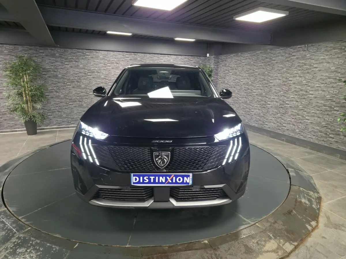 Vue avant d'un Peugeot 3008 noir 2025 avec phares LED griffes et calandre noire laquée en showroom.