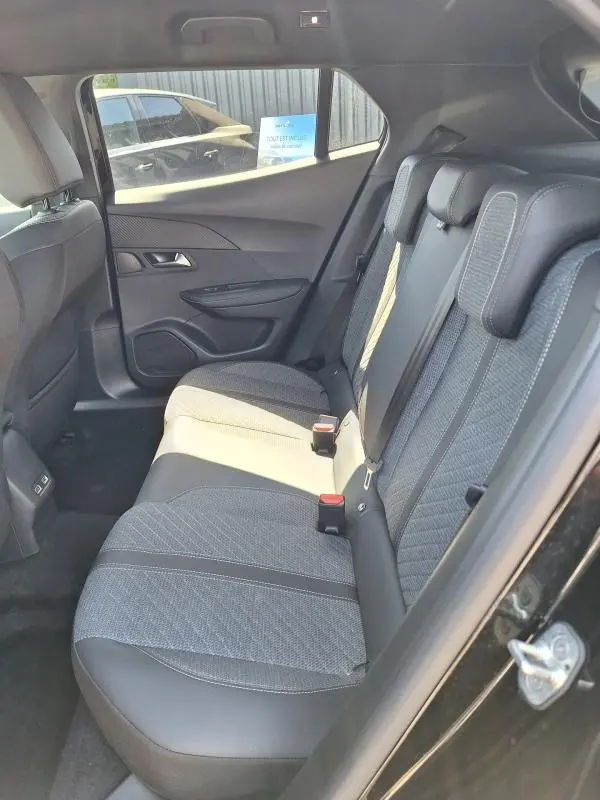 Vue intérieure côté gauche des sièges arrière en tissu gris et cuir noir du Peugeot 2008 Hybrid 136 e-DCS6 Allure noir 2025.