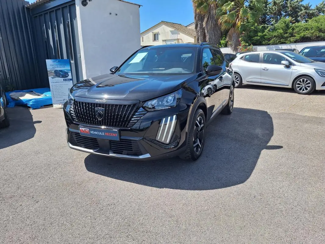 Peugeot 2008 Hybrid noir en 3/4 avant droit, avec barres de toit et jantes alliage 17 pouces visibles.