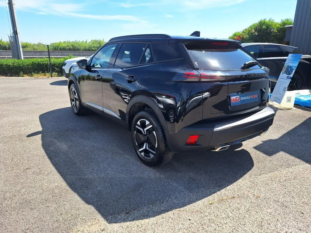 Peugeot 2008 Hybrid noir vue 3/4 arrière droit avec jantes alliage 17 pouces et barres de toit visibles.