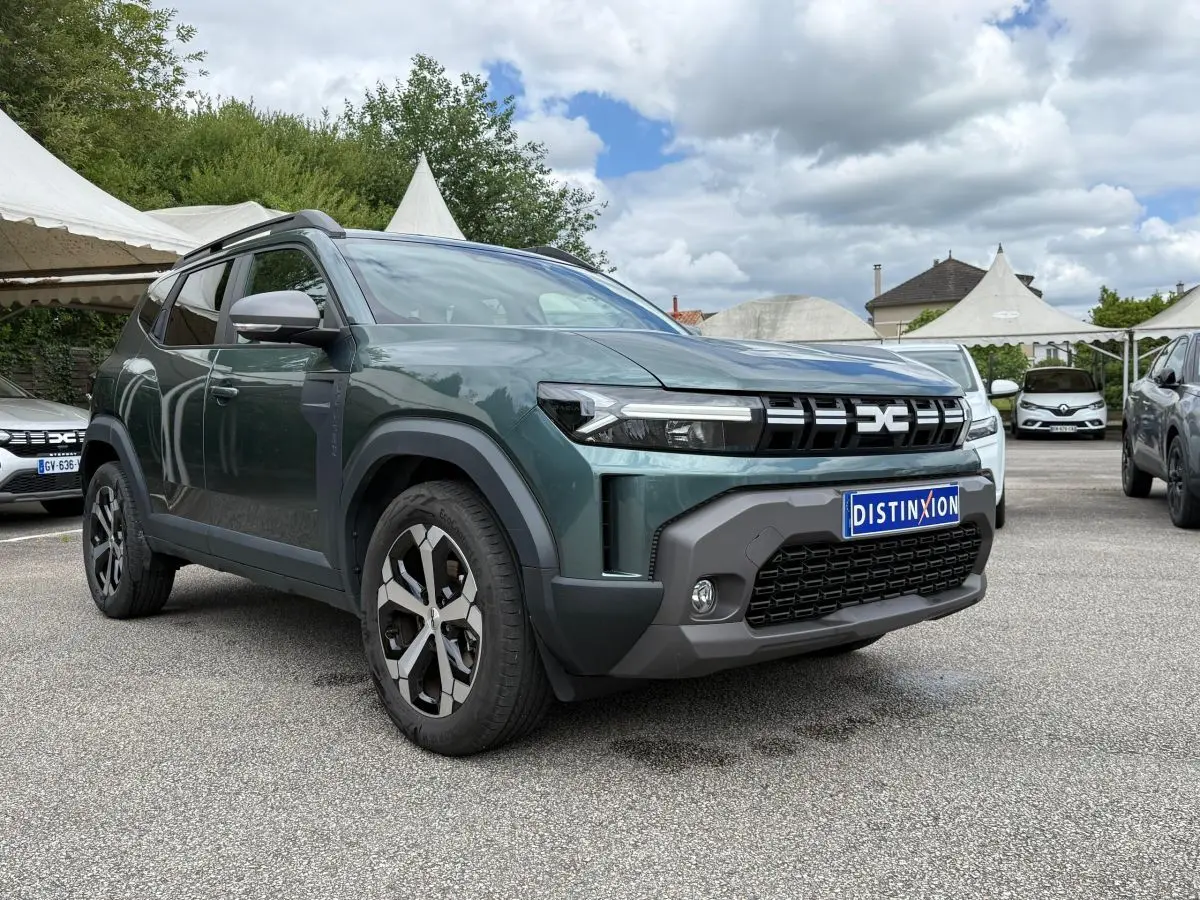 Vue 3/4 avant gauche d’un Dacia Duster Hybrid 140 Journey vert cèdre avec calandre noire et jantes bicolores.