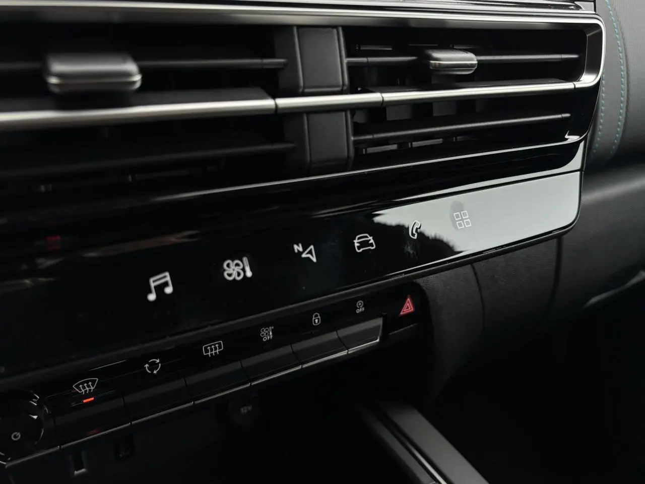 Détail de la console centrale noire brillante du Citroën C5 Aircross 2025 avec commandes tactiles et aérateurs horizontaux.