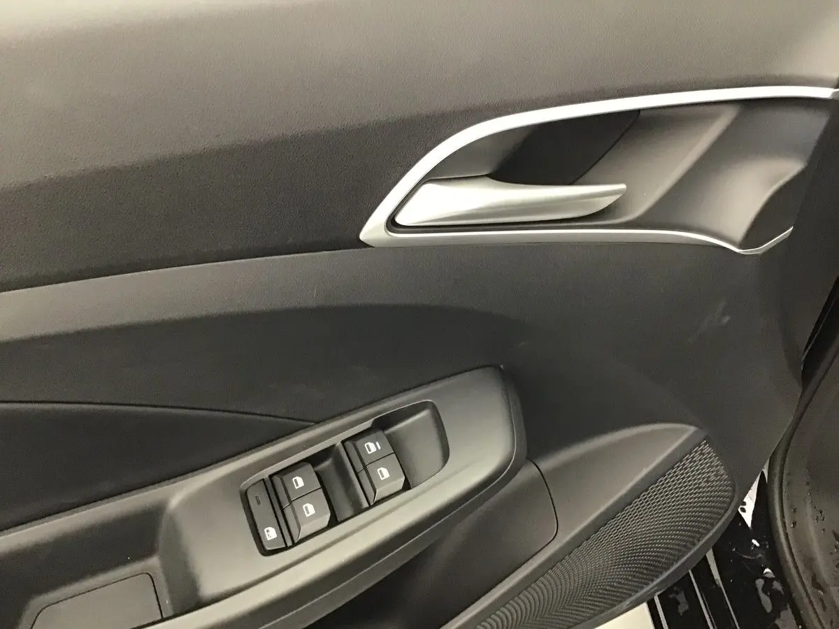 Détail de la porte côté conducteur de la MG3 1.5 Hybrid+ 195 Luxury en Pebble Black, avec commandes de vitres et poignée argentée.