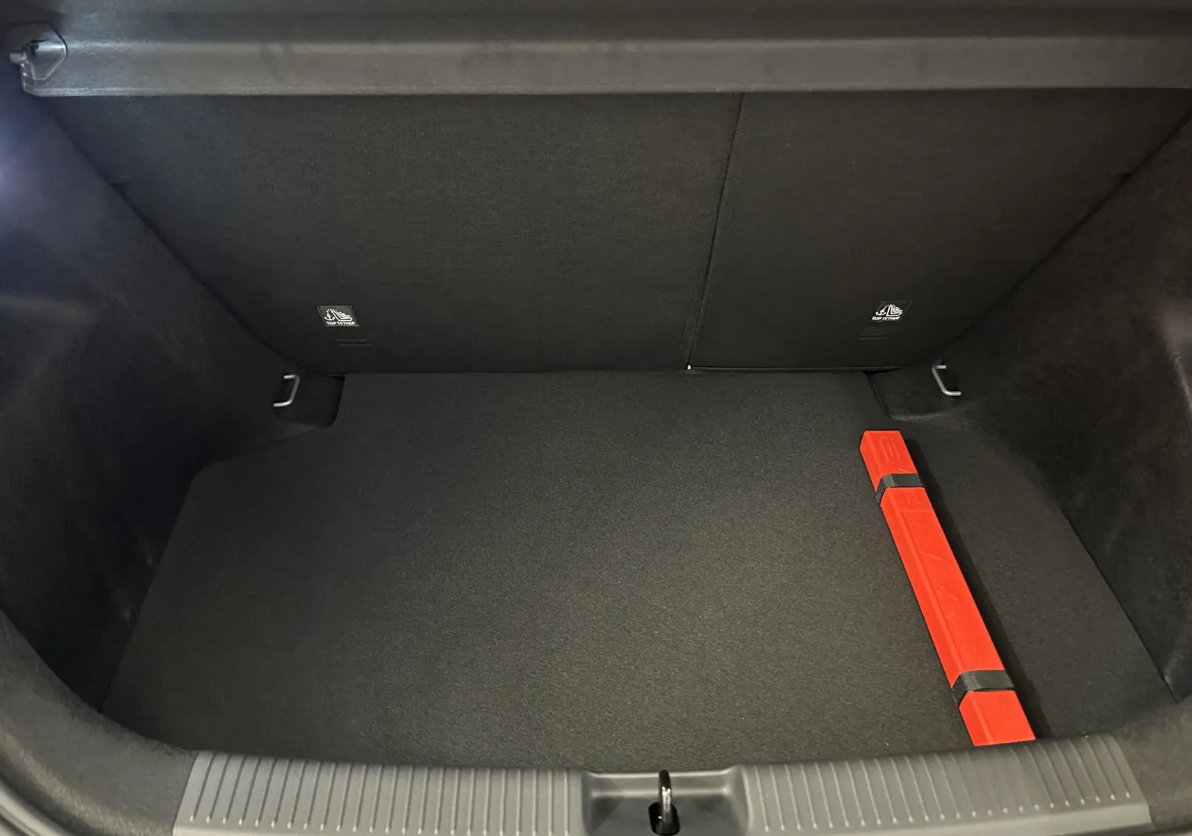 Coffre ouvert de MG3 Pebble Black 2026 vu de dessus, montrant un espace vide avec un triangle de signalisation rouge.