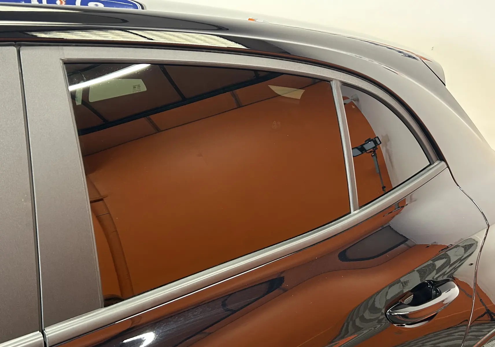 Gros plan sur la porte arrière côté droit du MG3 Hybrid+ 195 Luxury Pebble Black avec reflet et poignée chromée visible.