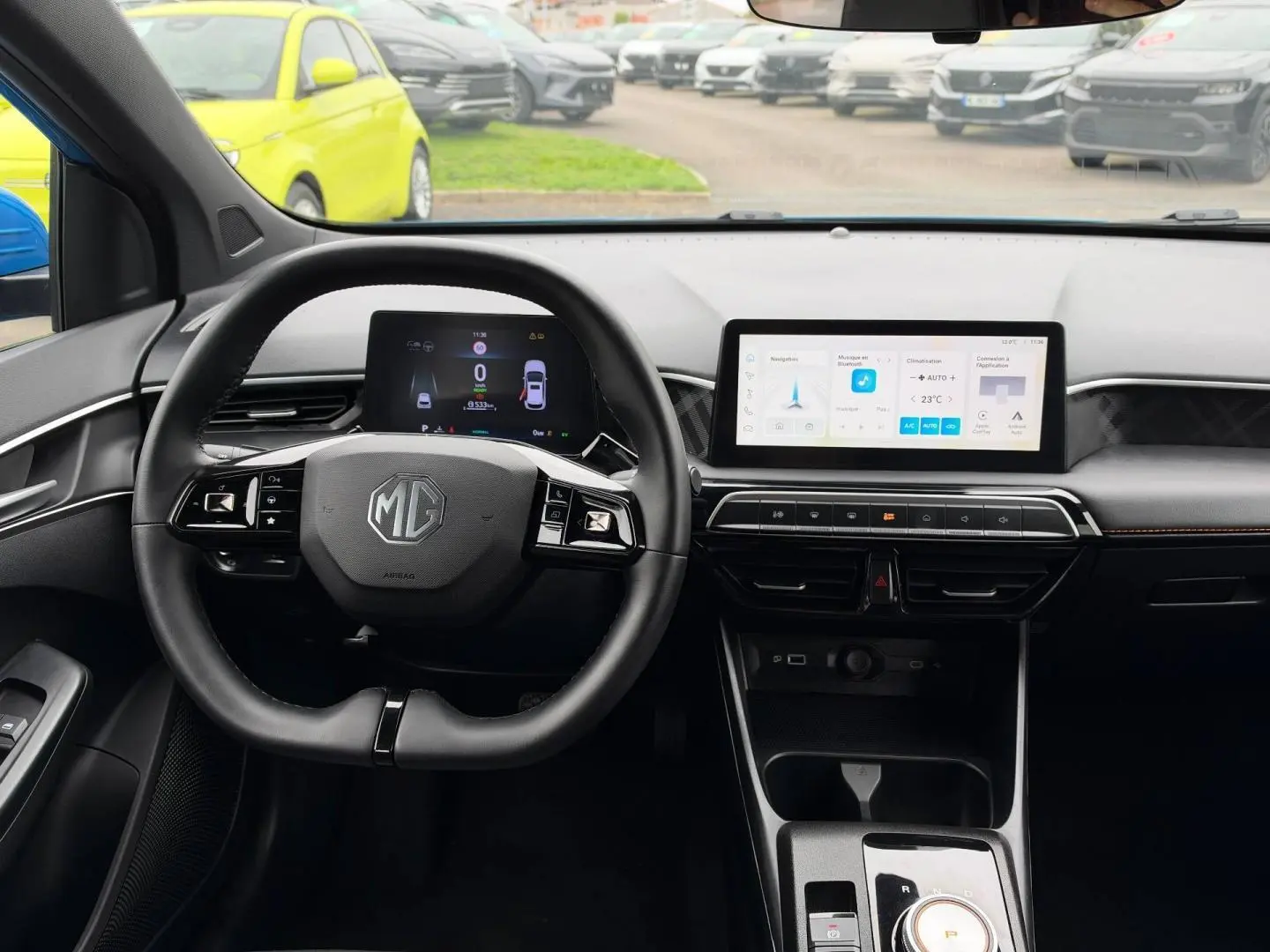 Vue intérieure frontale du poste de conduite de la MG3 1.5 Hybrid+ 195ch Luxury avec écran tactile et volant multifonction noir.
